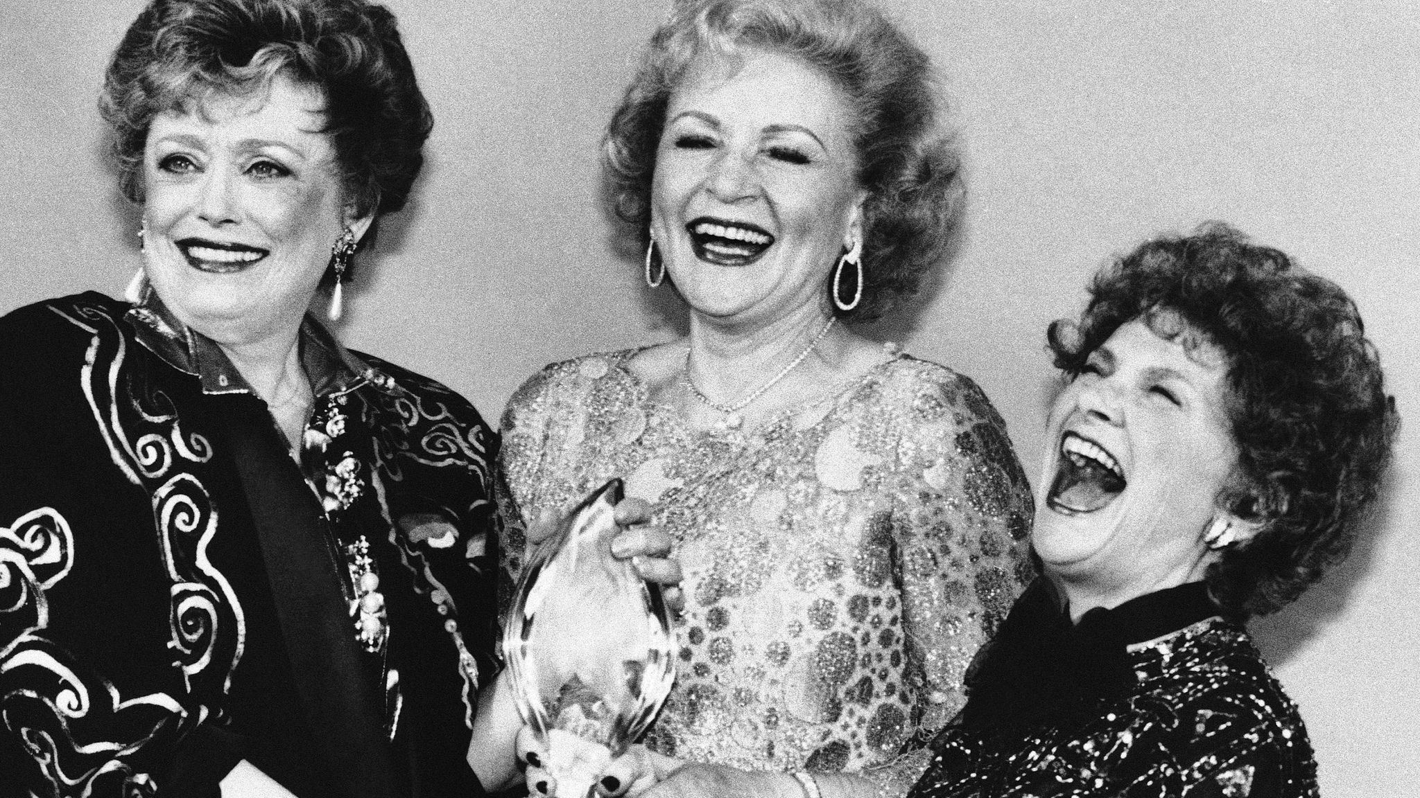 Actresses Rue McClanahan, left, Betty White, centrE, and Estelle Getty, right, share a moment after winning Favourite New Television Comedy Programme at The People&#39;s Choice Awards in 1986. Pic: AP