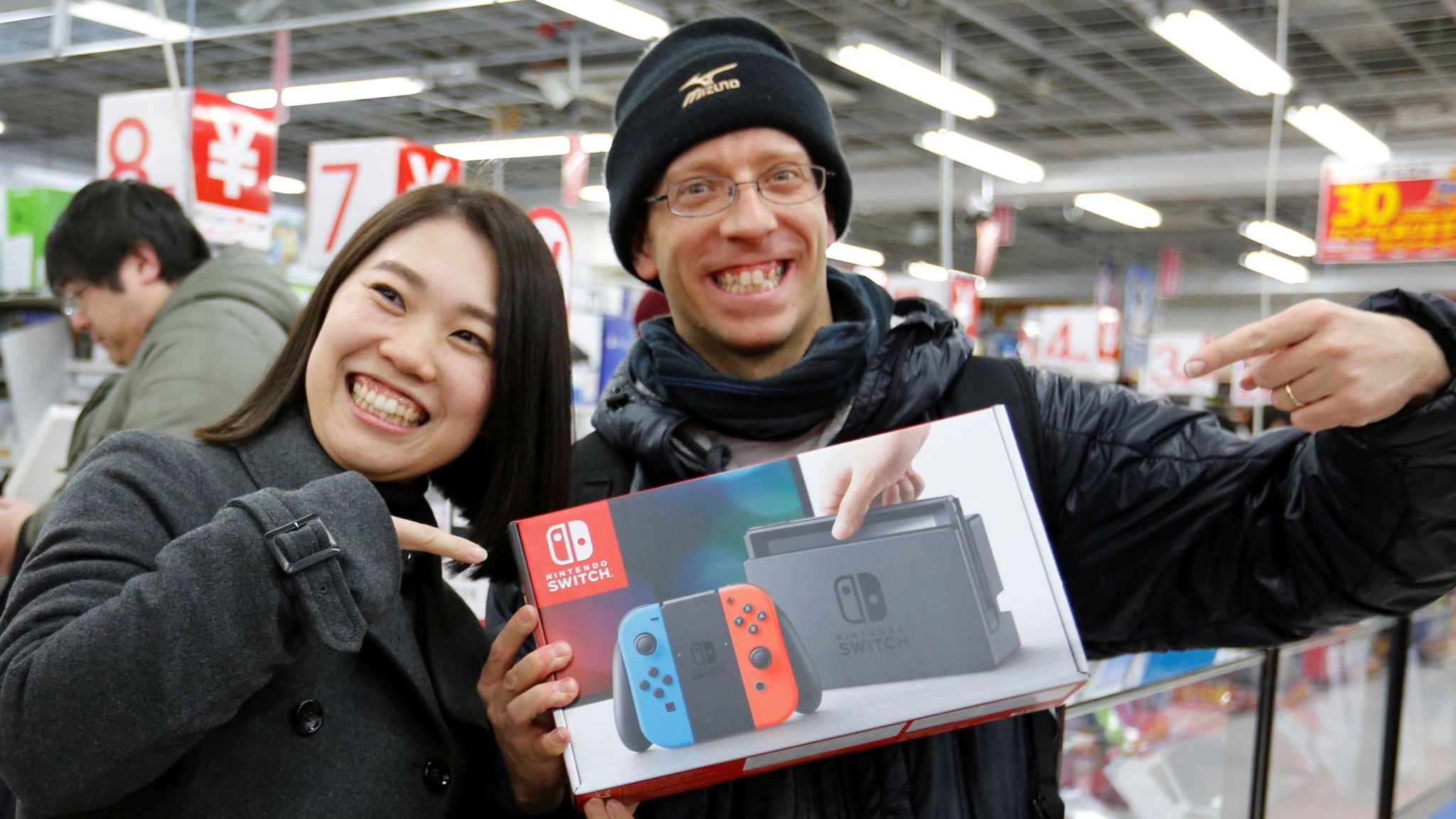 Nao Imoto (L) and her husband David Flores poses with their Nintendo Switch game console after buying it at an electronics store in Tokyo, Japan March 3, 2017. REUTERS/Toru Hanai