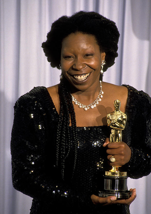 Whoopi Goldberg holding her Oscar 