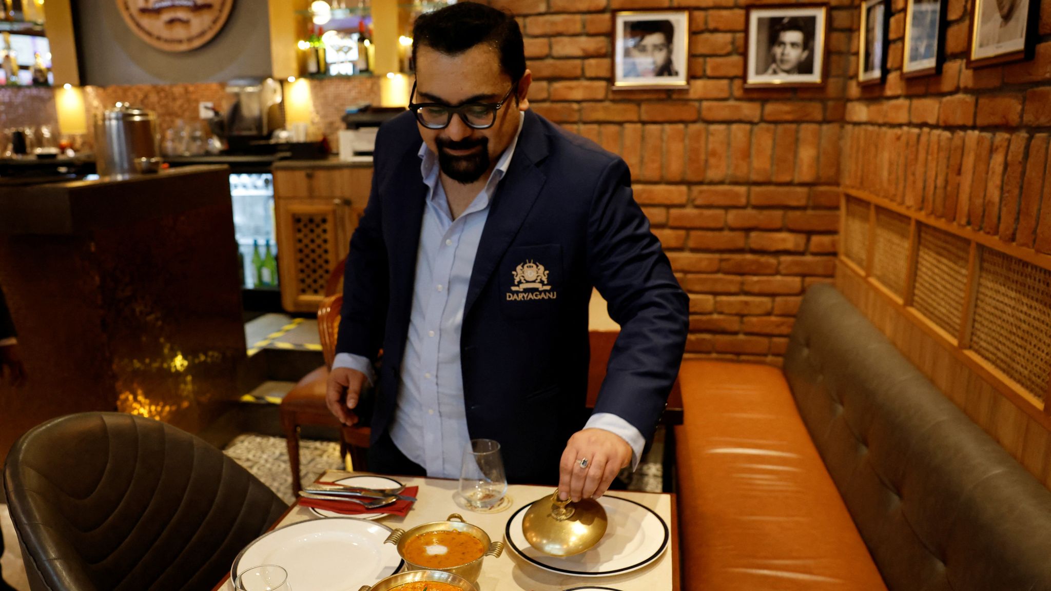 Amit Bagga, CEO of Daryaganj with a butter chicken and the lentil dish Dal Makhani Pic; Reuters