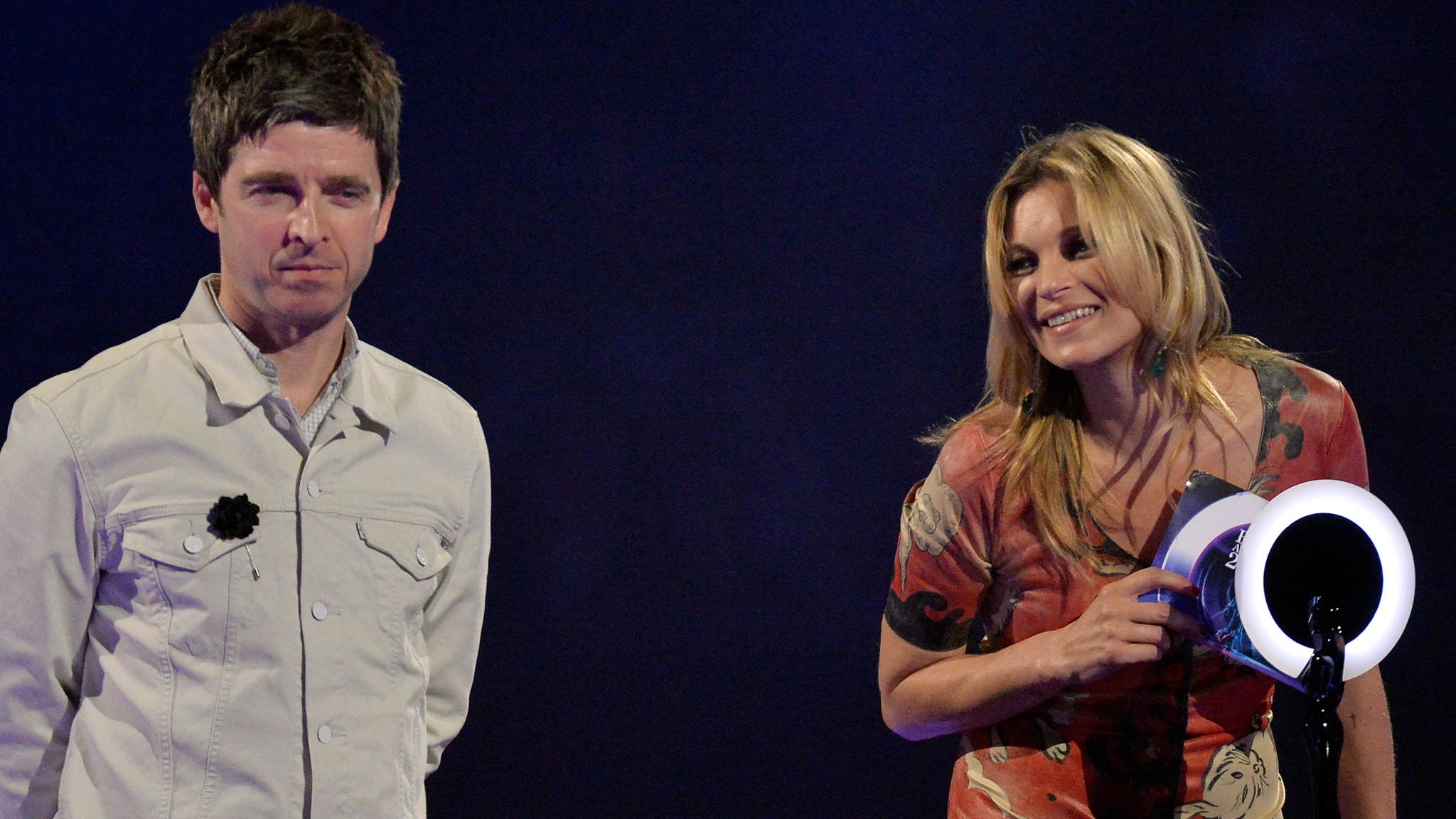 Model Kate Moss accepts the British Male Solo Artist award on behalf of David Bowie as musician Noel Gallagher looks on at the BRIT Awards in 2014