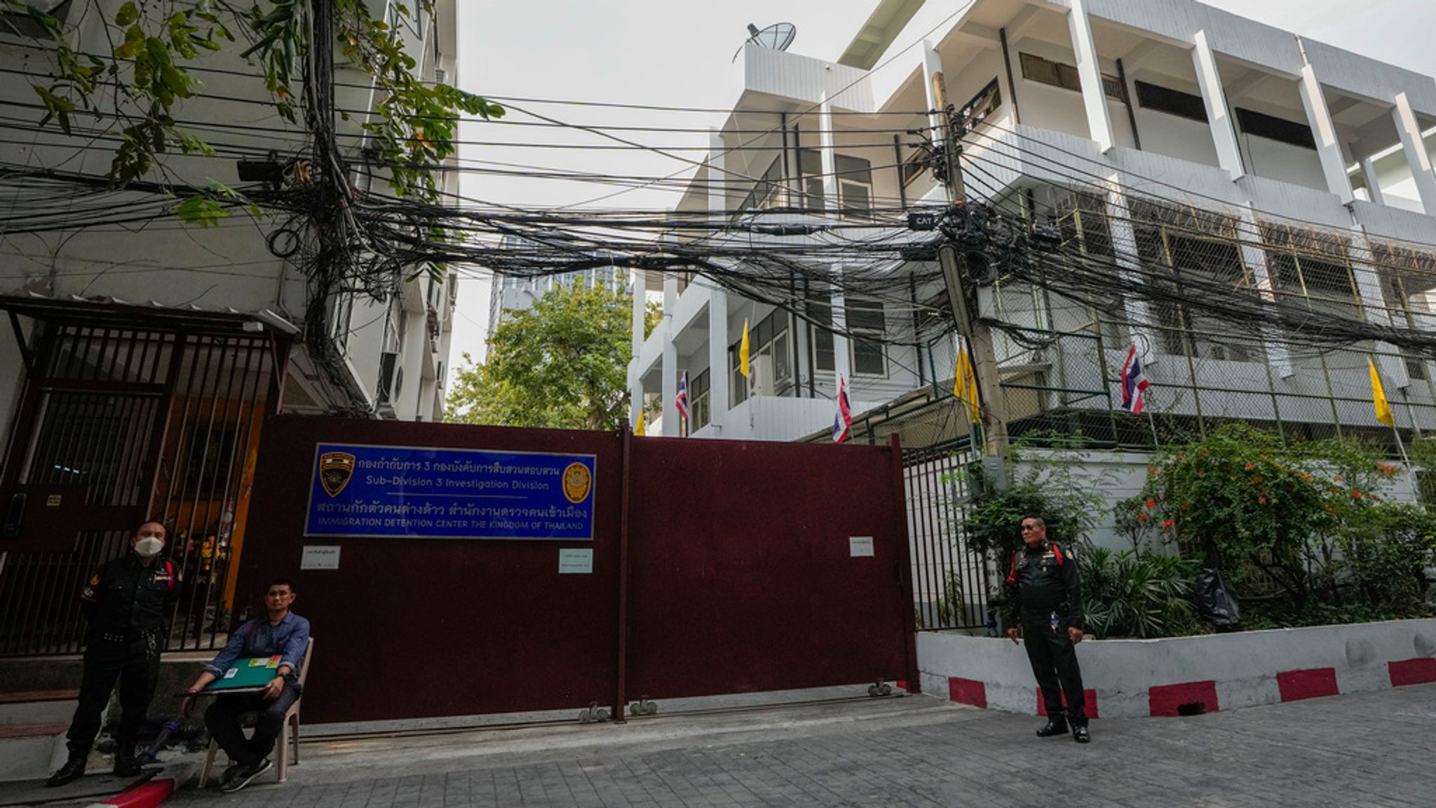 Security members stand guard outside the Immigration Detention Center in Bangkok, Thailand. Pic: AP/Sakchai Lalit