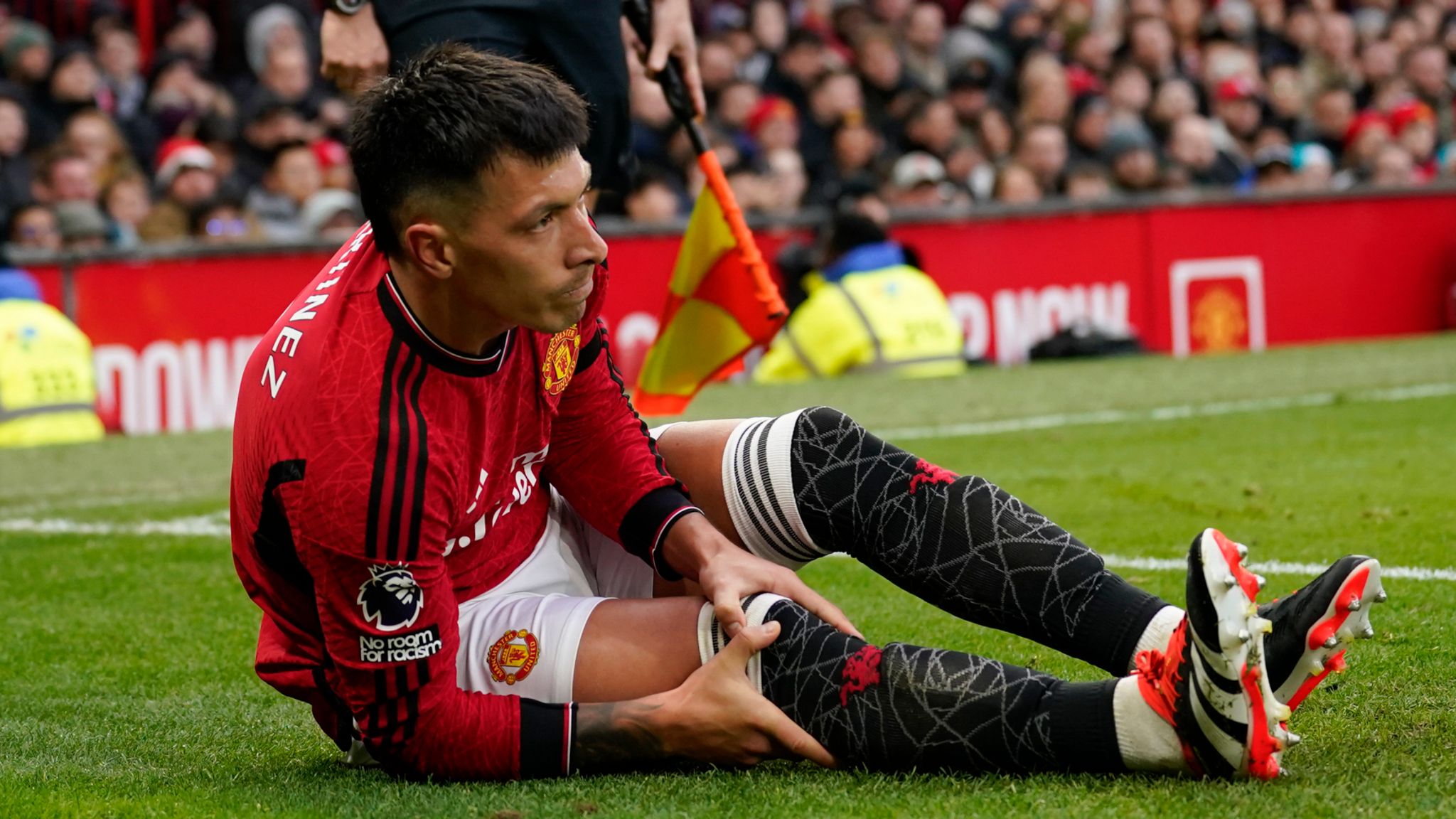 Manchester United's Lisandro Martinez holds his knee after an injury