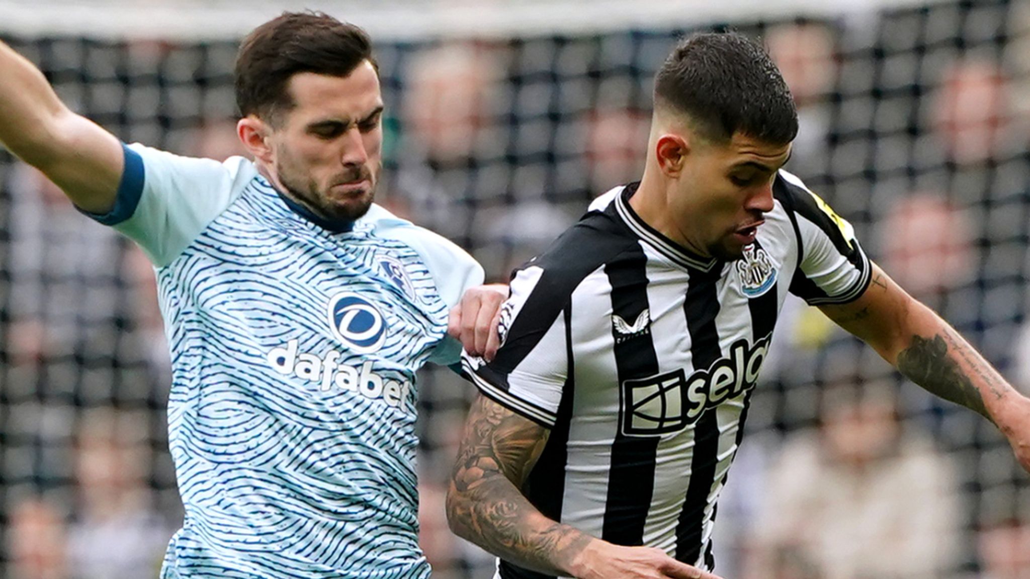 Bruno Guimaraes and Lewis Cook battle for the ball