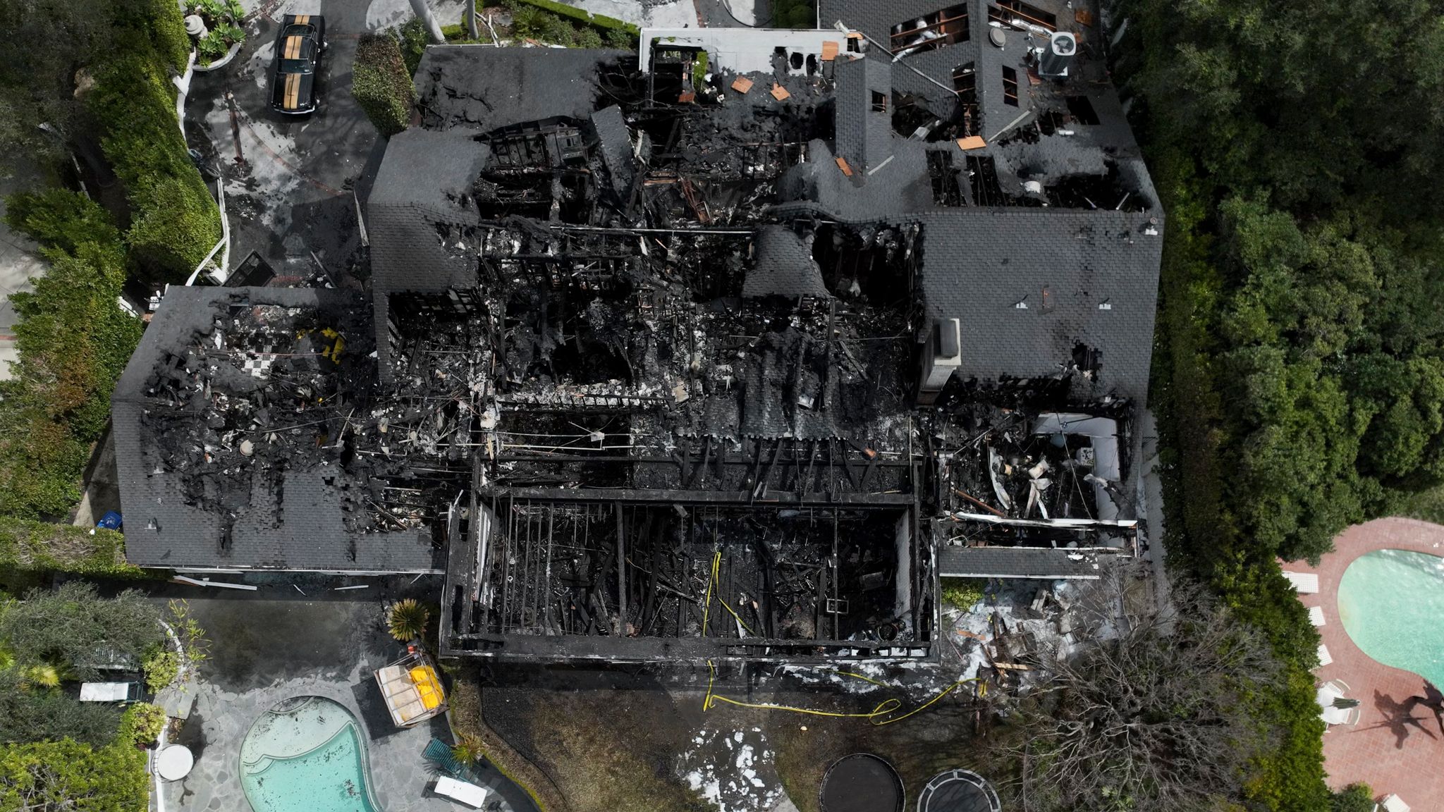 An aerial view shows a fire-damaged property, which appears to belong to Cara Delevingne, Friday, March 15, 2024, in the Studio City section of Los Angeles. (AP Photo/Jae C. Hong)