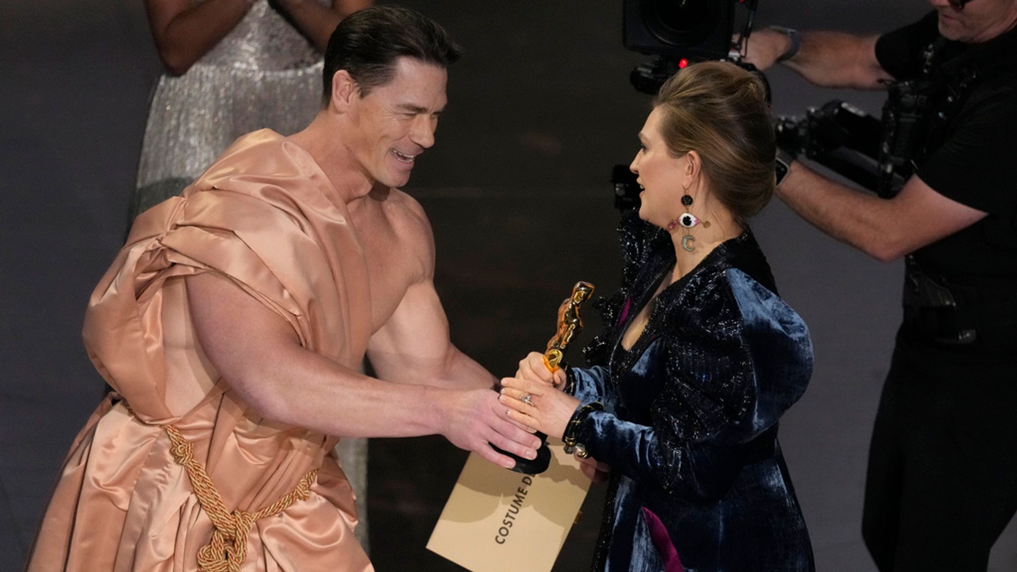 (L-R): John Cena and costume design to Holly Waddington. Pic: AP