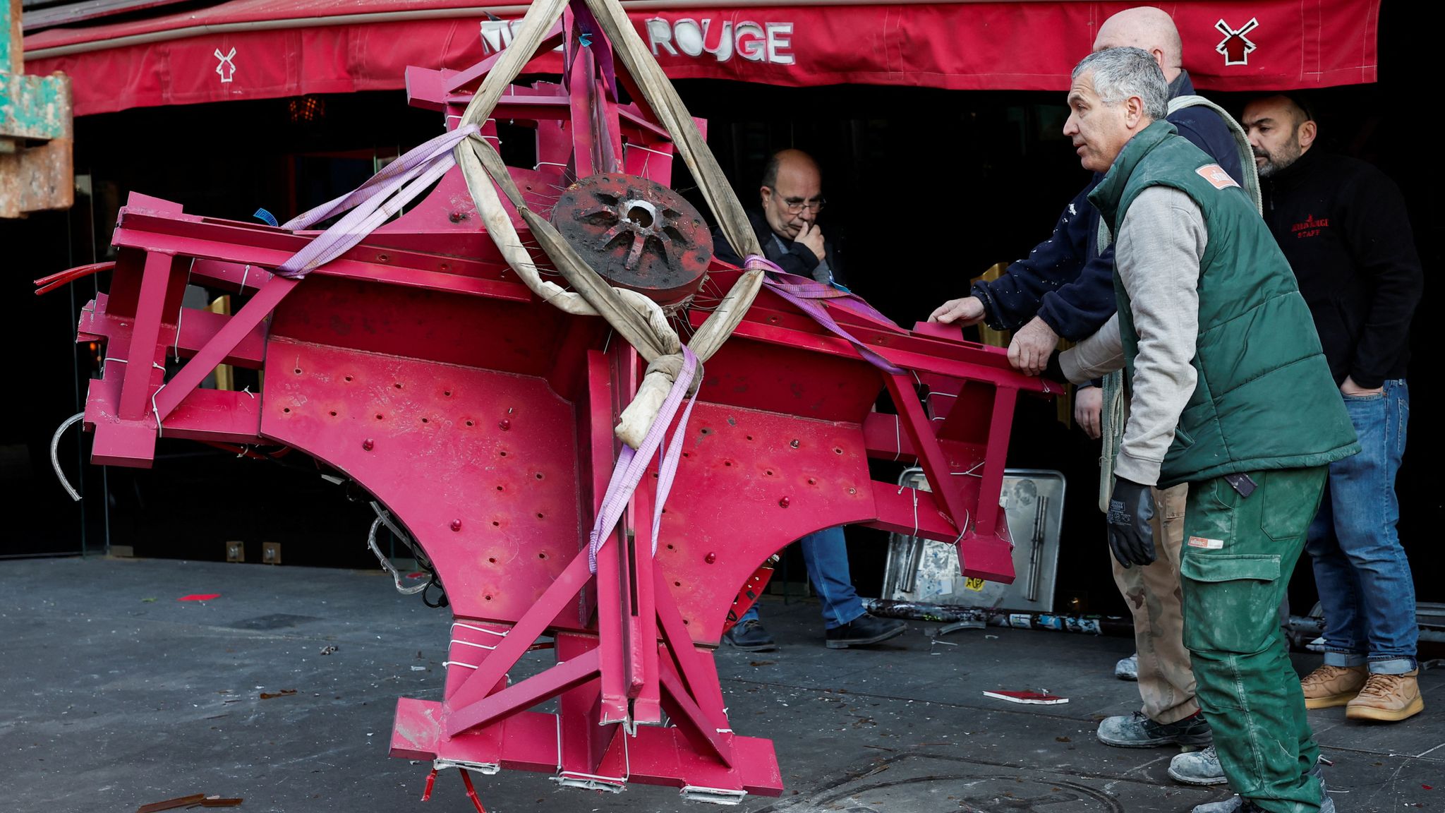 Sails of the landmark red windmill atop the Moulin Rouge, Paris&#39; most famous cabaret club, are seen on the ground after a fall off during the night in Paris, France, April 25, 2024. REUTERS/Benoit Tessier 