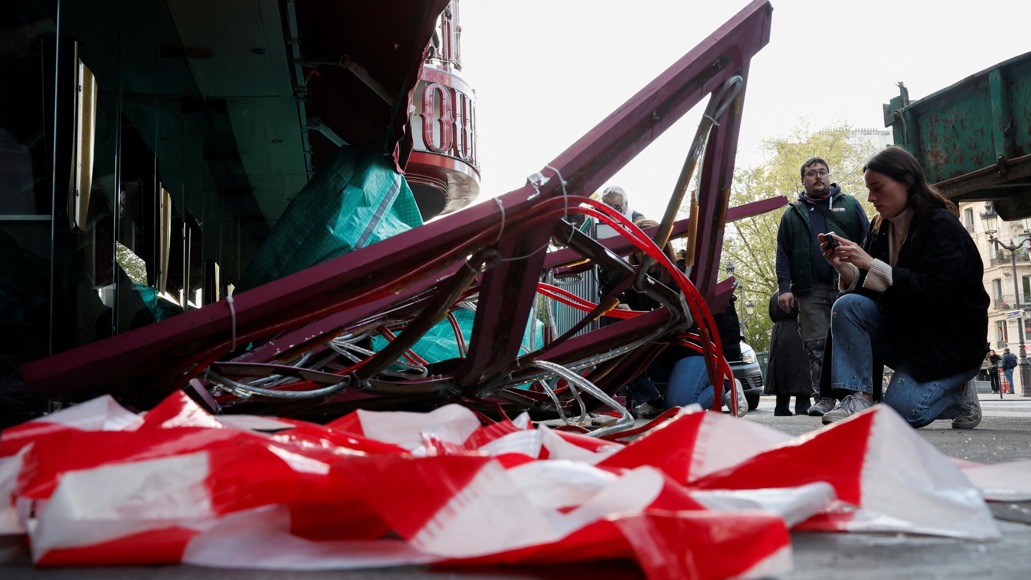 Sails of the landmark red windmill atop the Moulin Rouge, Paris&#39; most famous cabaret club, are seen on the ground after a fall off during the night in Paris, France, April 25, 2024. REUTERS/Benoit Tessier 