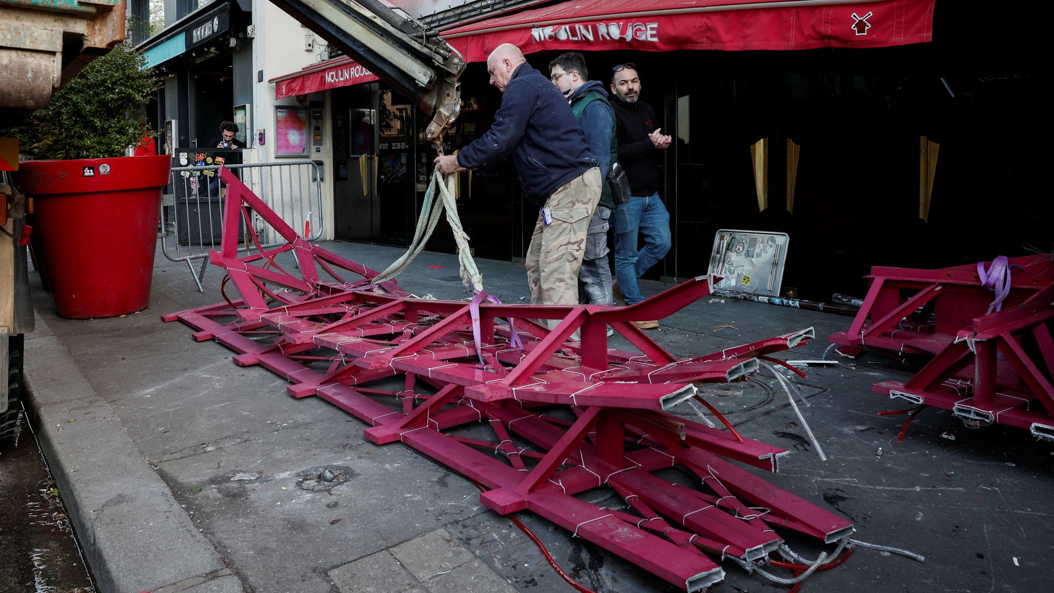 Sails of the landmark red windmill atop the Moulin Rouge, Paris&#39; most famous cabaret club, are seen on the ground after a fall off during the night in Paris, France, April 25, 2024. REUTERS/Benoit Tessier 