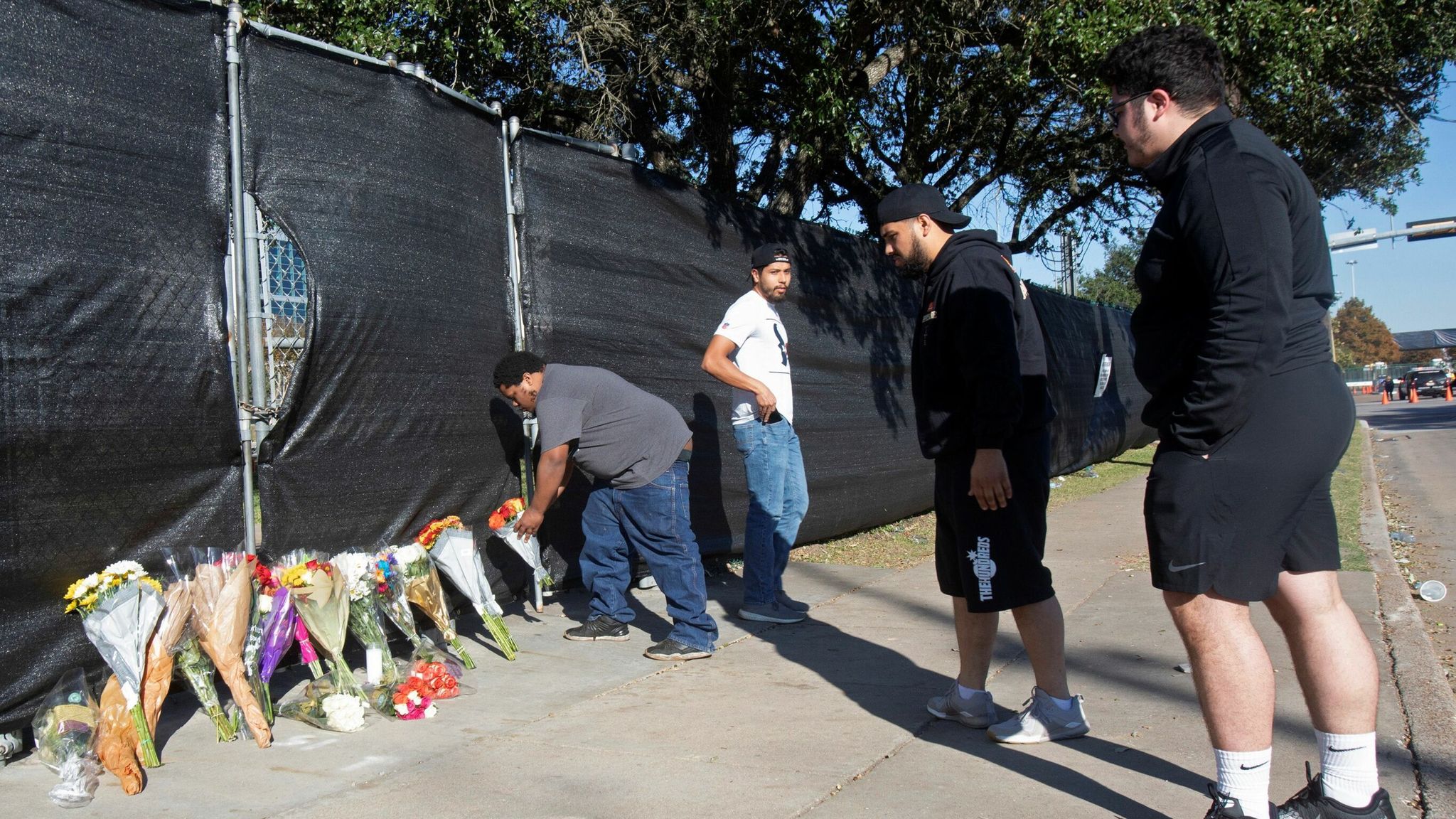 Matthew Shelton, Diego Rivera, Anthony Perez and Juan Carillo place flowers on a gate to NRG Park, after a deadly crush of fans during a performance the night before at the Astroworld Festival by rapper Travis Scott in Houston, Texas, U.S. November 6, 2021. REUTERS/Daniel Kramer