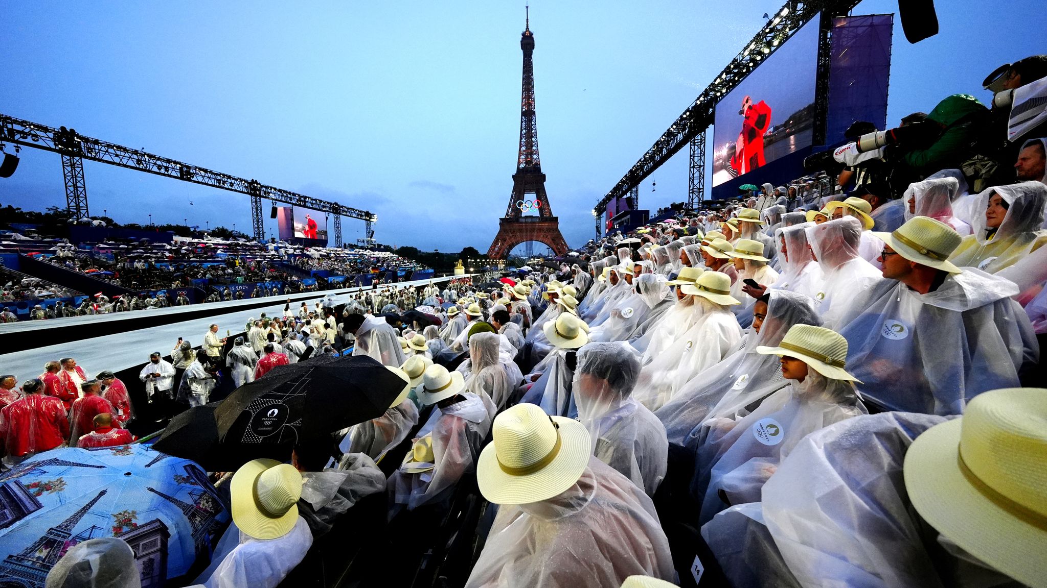 Spectators shelter from the rain at the Trocadero during the opening ceremony of the Paris 2024 Olympic Games Pic: PA