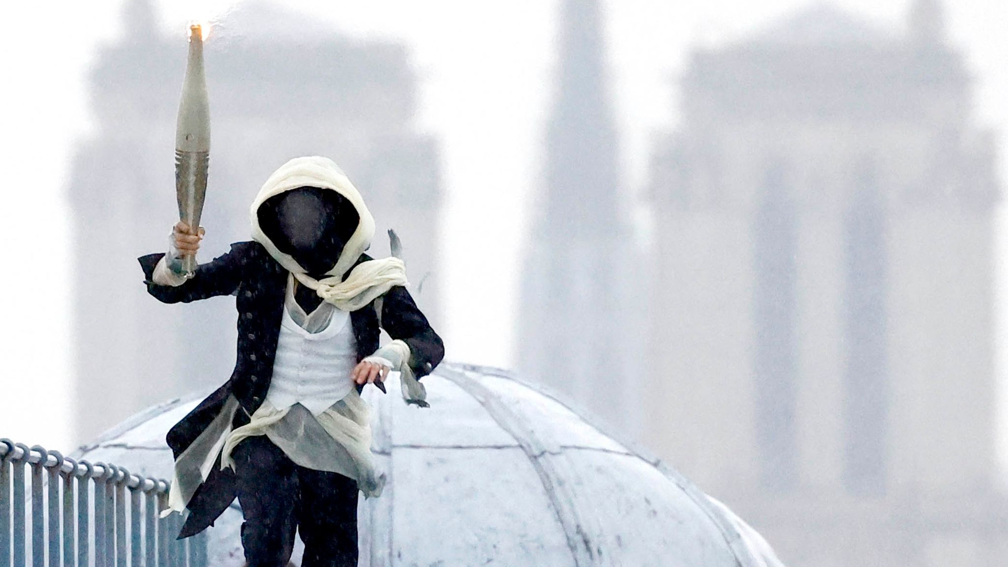 The torchbearer runs atop the Musee d'Orsay. Pic: Reuters