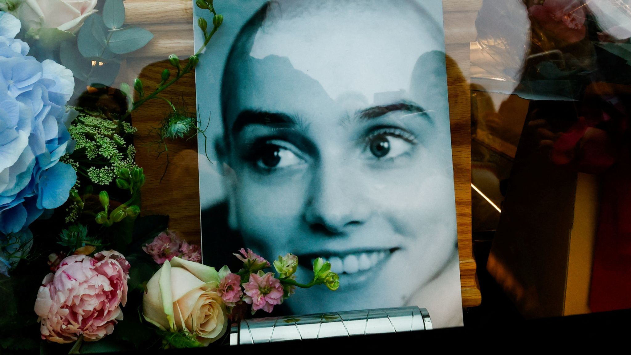 A person gestures behind a hearse carrying the coffin of late Irish singer Sinead O'Connor as it passes by during her funeral procession where fans line the street to say their last goodbye to her, in Bray, Ireland, August 8, 2023. REUTERS/Clodagh Kilcoyne