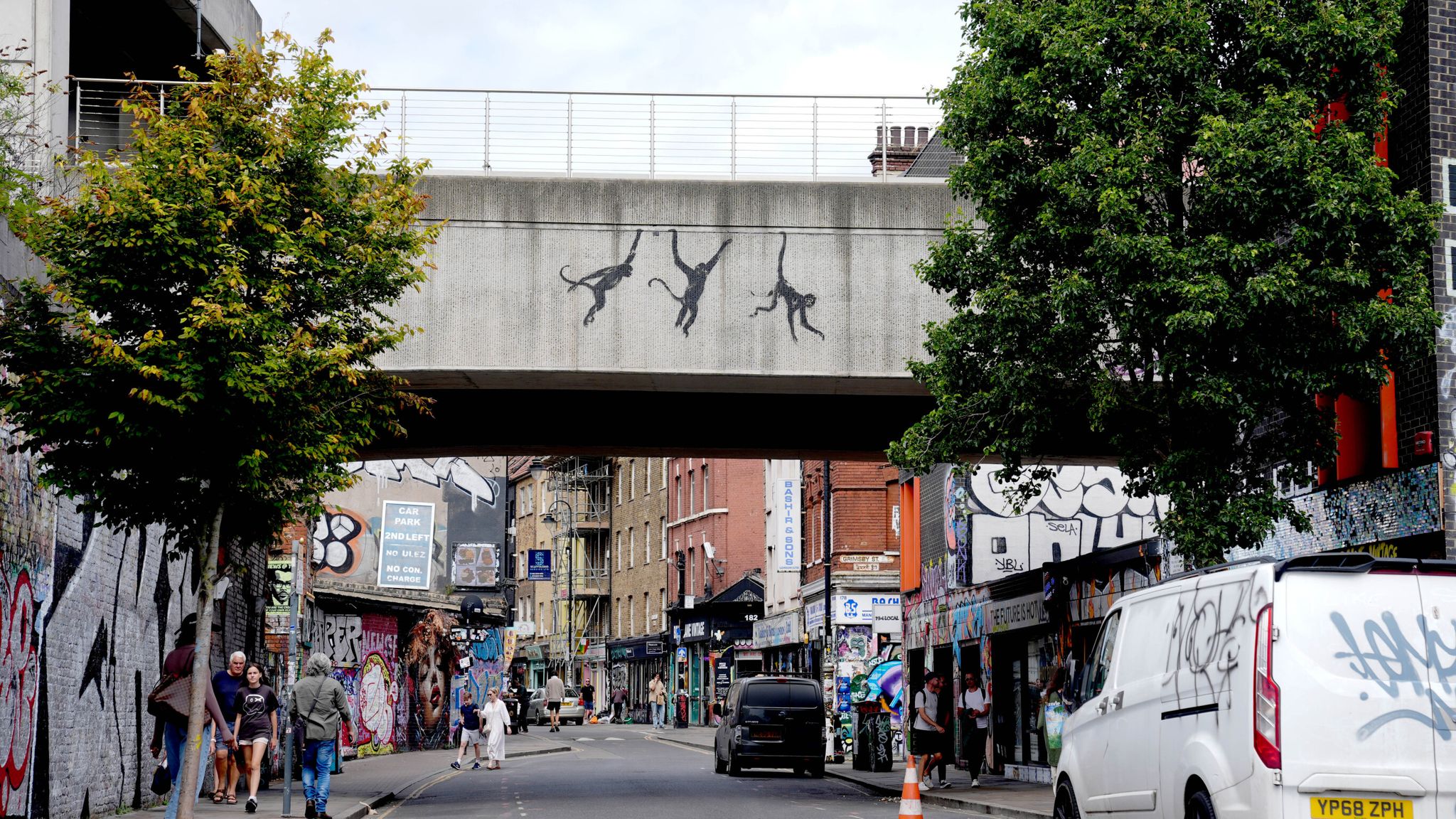 A new artwork depicting three monkeys unveiled by Banksy, painted on a bridge in Brick Lane. Pic: PA