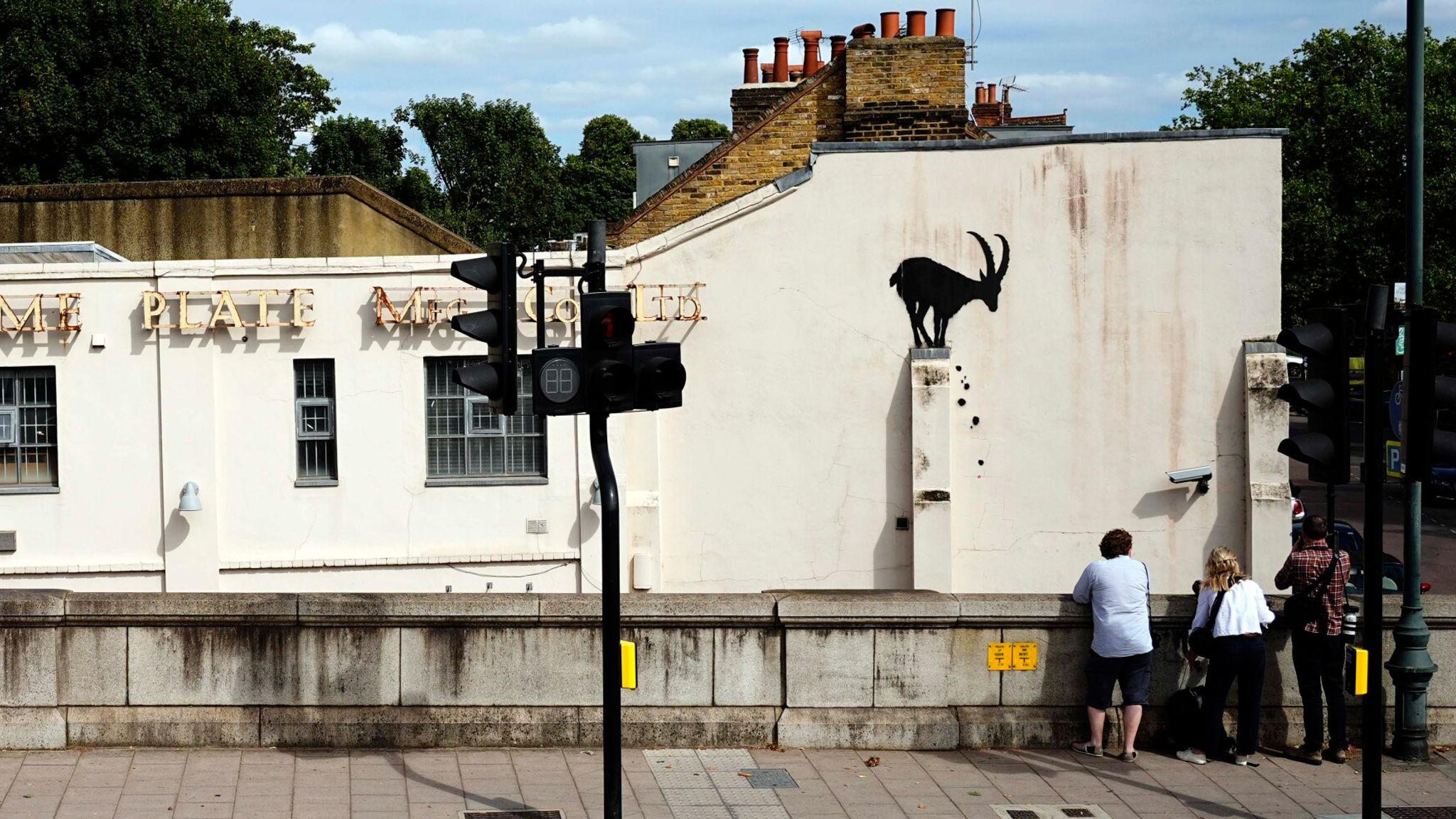 Members of the public look on at the new Banksy artwork. Pic: PA