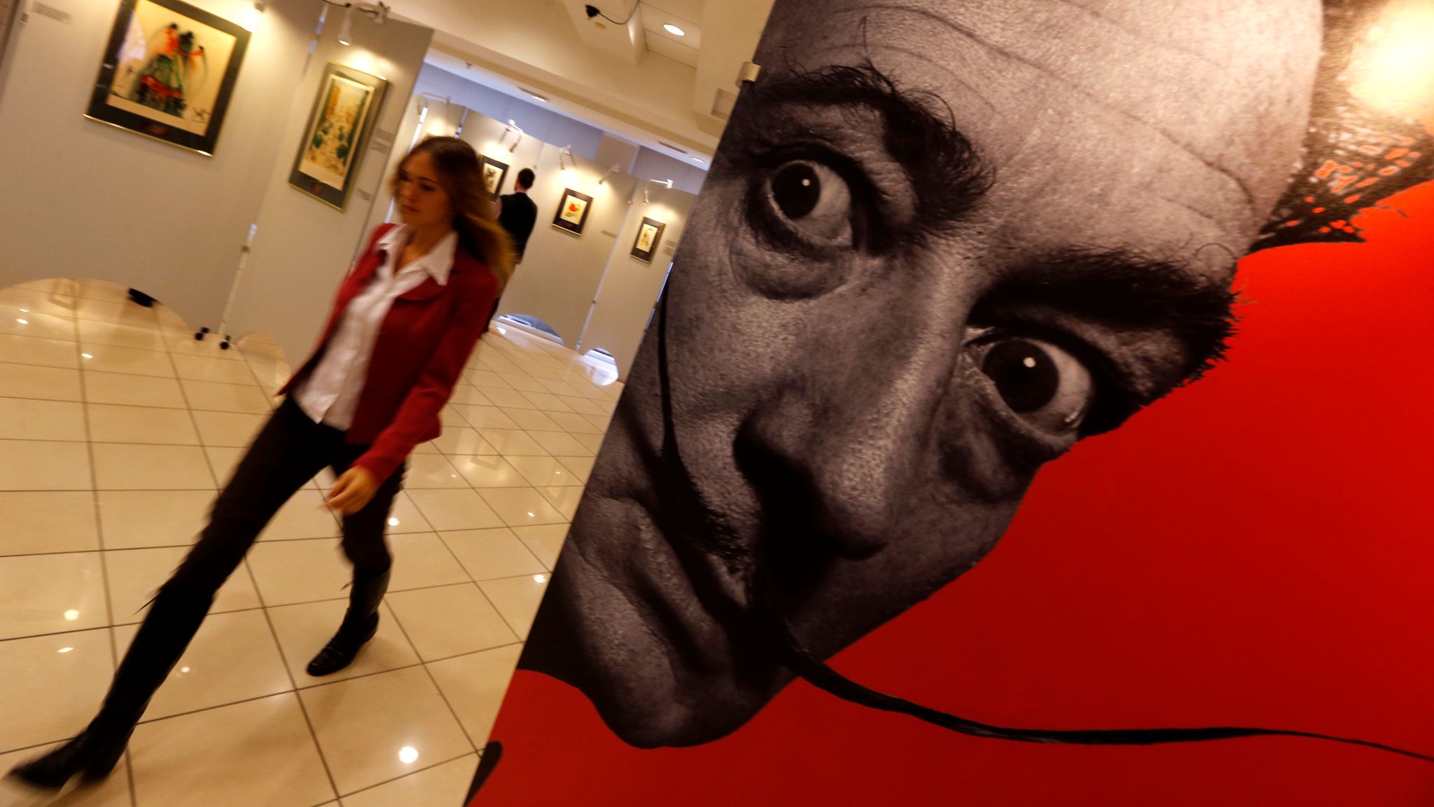 A visitor walks past a portrait of Salvador Dali during the exhibition "Cryptography" in St. Petersburg October 5, 2014. The exhibition features 61 original colour graphic works of Salvador Dali which were collected from private collections and galleries in Europe and America, organizers said. REUTERS/Alexander Demianchuk (RUSSIA - Tags: SOCIETY)