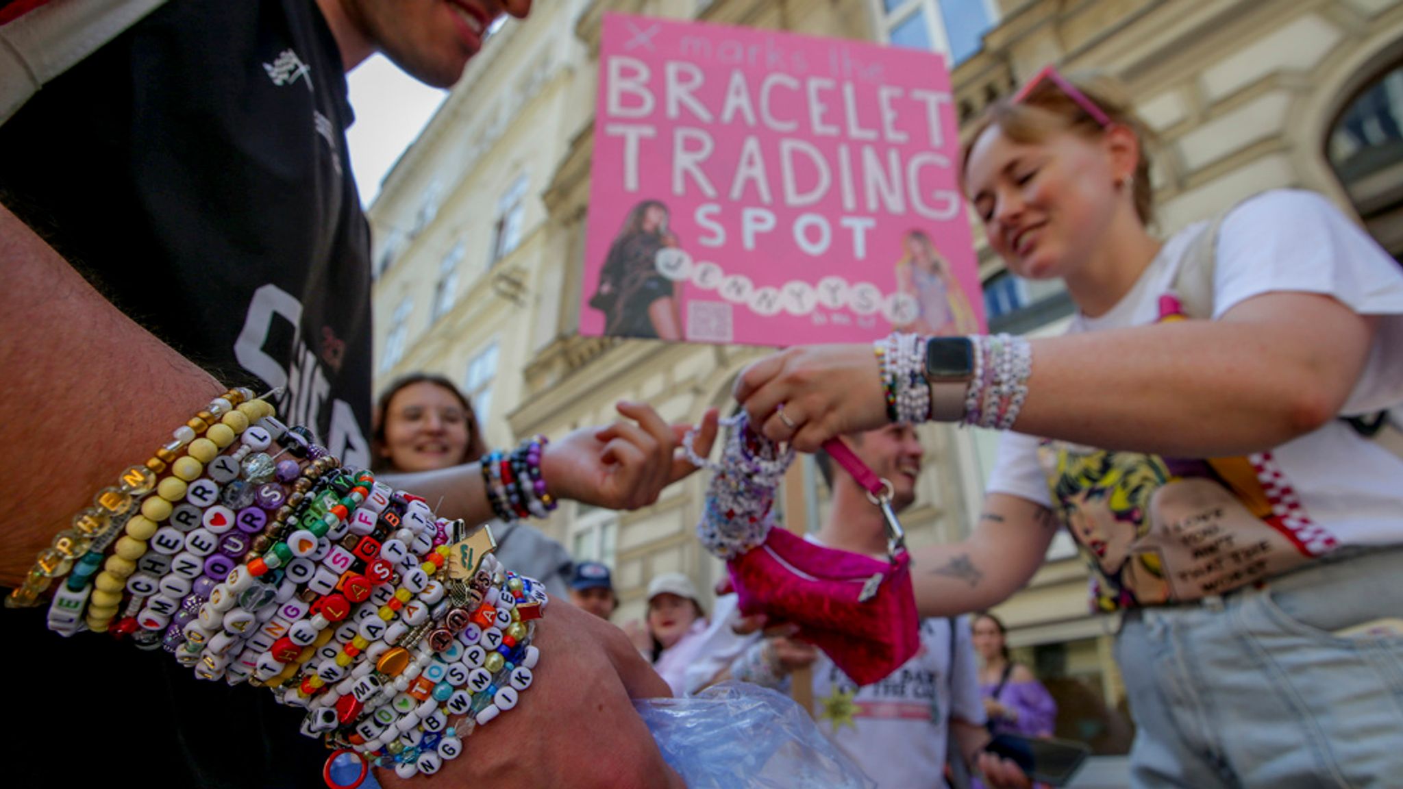 Swifties trade bracelets in the city centre in Vienna on Thursday, Aug.8, 2024. Organizers of three Taylor Swift concerts in the stadium in Vienna this week called them off on Wednesday after officials announced arrests over an apparent plot to launch an attack on an event in the Vienna area such as the concerts. (AP Photo/Heinz-Peter Bader)