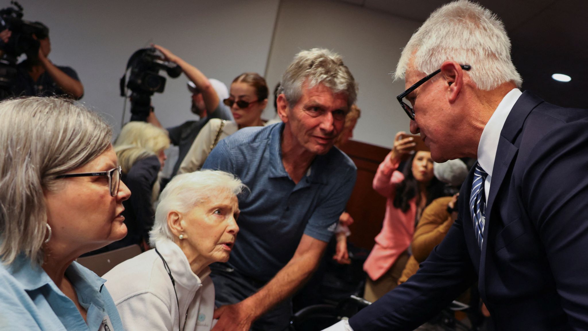 Los Angeles County District Attorney George Gascon shakes hands with Joan Andersen VanderMolen, sister of Kitty Menendez, at the end of a news conference on a decision in the case of brothers Erik and Lyle Menendez, who have spent 34 years in prison for the shotgun murder of their parents, in Los Angeles, California, U.S., October 24, 2024. REUTERS/Mike Blake