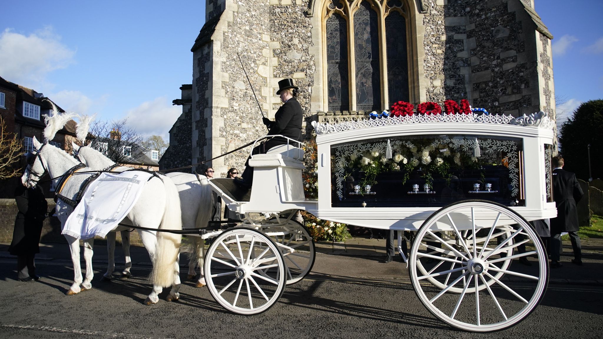 A horse-drawn carriage carrying the coffin of Liam Payne arrives for the funeral service. Pic: PA