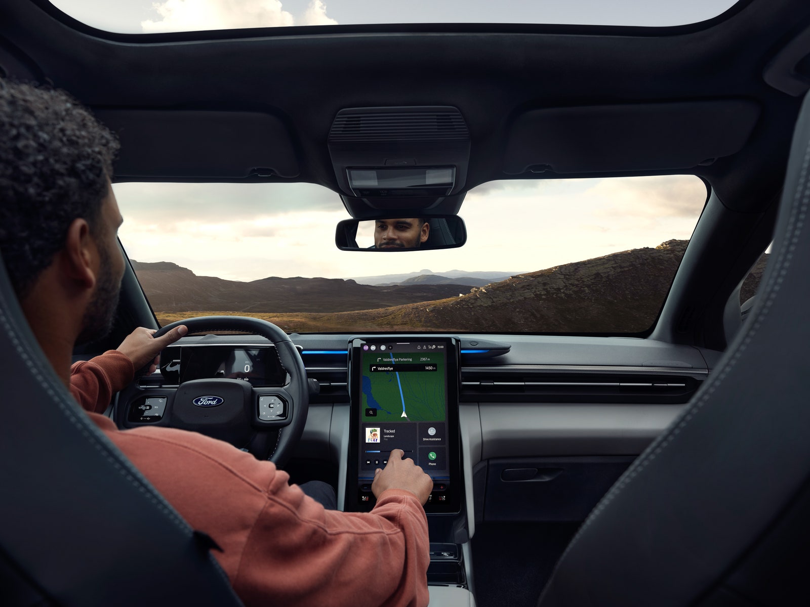 POV from the backseat of a car with a man driving