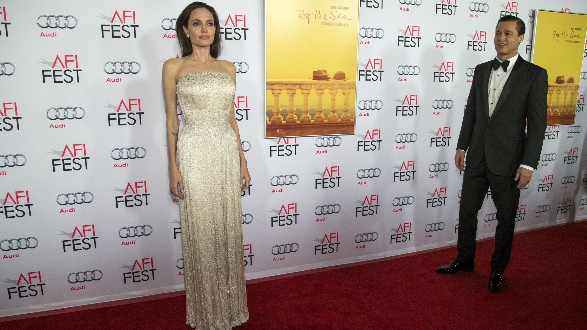 Angelina Jolie poses as Brad Pitt stands nearby at the premiere of "By the Sea" in 2015. Pic: Reuters