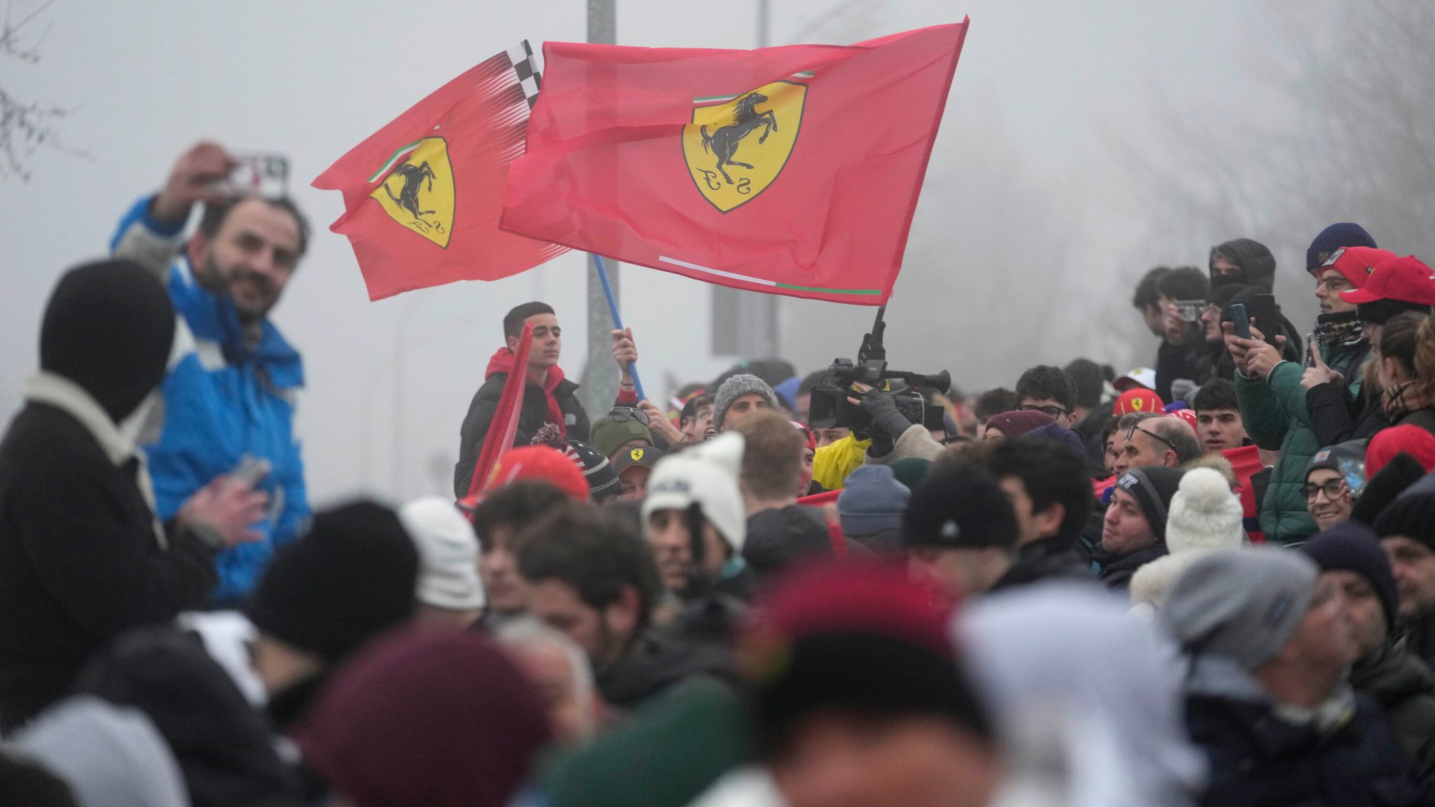 People gather outside the Ferrari track as they wait for British driver Lewis Hamilton who is scheduled to test a Ferrari Formula One SF-23, in Fiorano Modenese, Italy, Wednesday, Jan. 22, 2025. (AP Photo/Luca Bruno)