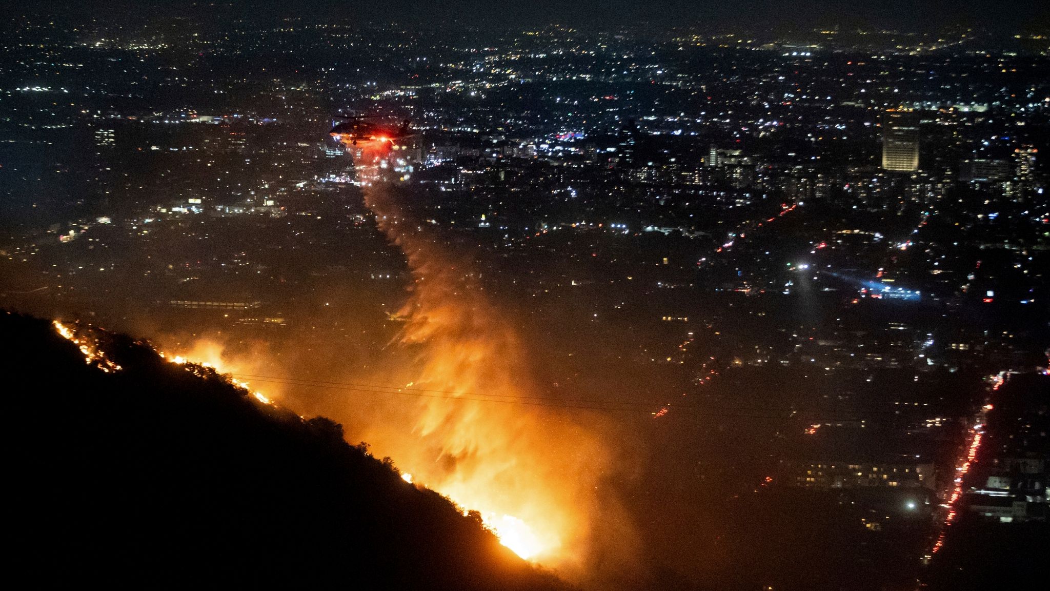 Water is dropped by helicopter on the burning Sunset Fire in the Hollywood Hills. Pic: AP