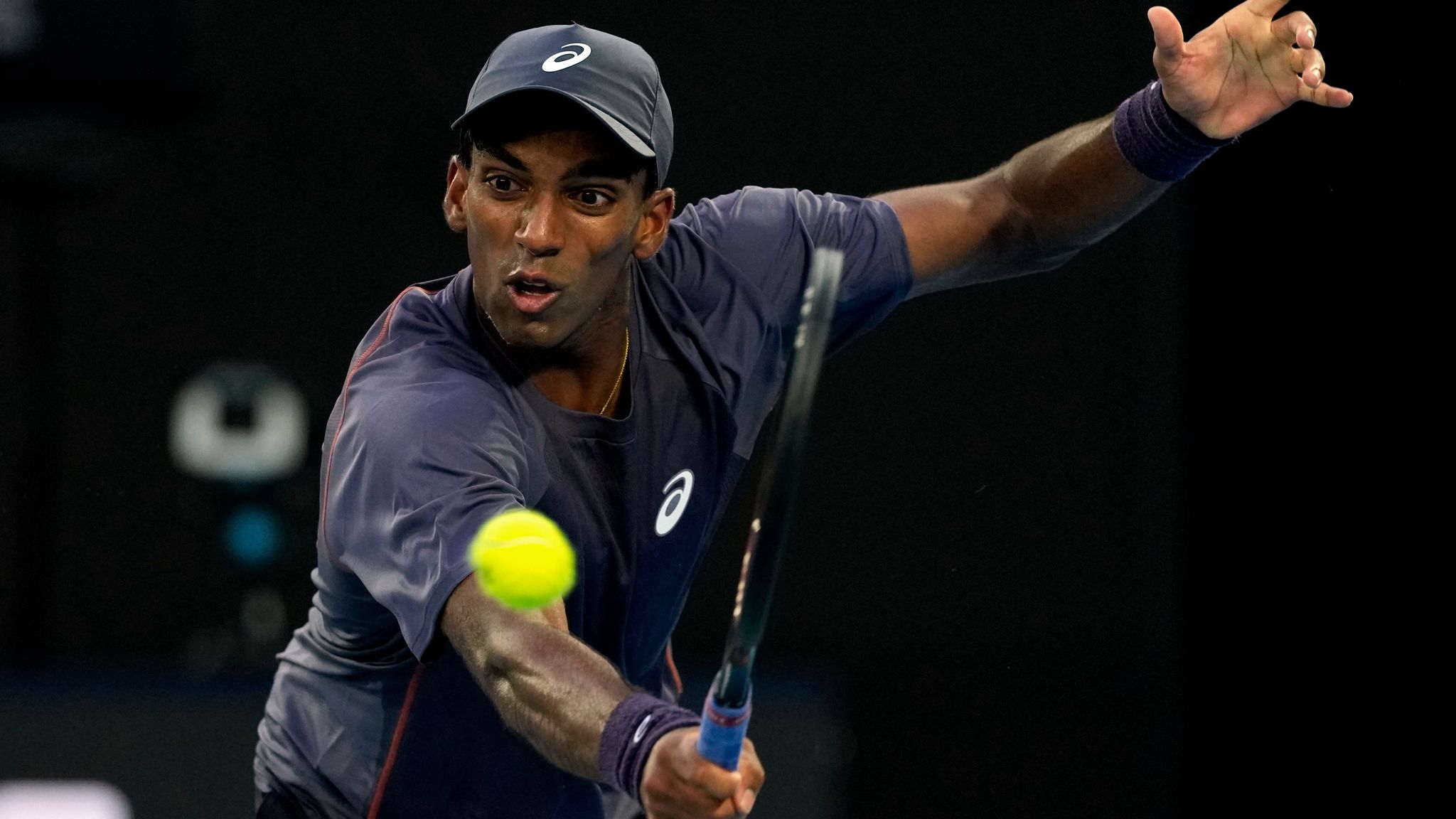 Nishesh Basavareddy of the U.S. plays a backhand return to Novak Djokovic of Serbia during their first round match at the Australian Open tennis championship in Melbourne, Australia, Monday, Jan. 13, 2025. (AP Photo/Asanka Brendon Ratnayake)